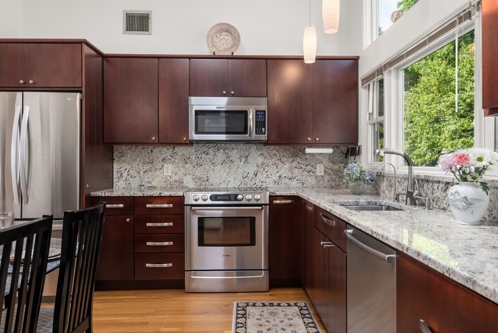 54 Clark Street Newton, MA 02459 - Photo 14 of 34 a kitchen with stainless steel appliances granite countertop a sink stove and microwave