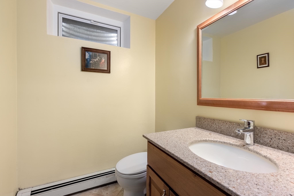 54 Clark Street Newton, MA 02459 - Photo 26 of 34 a bathroom with a granite countertop sink toilet and mirror