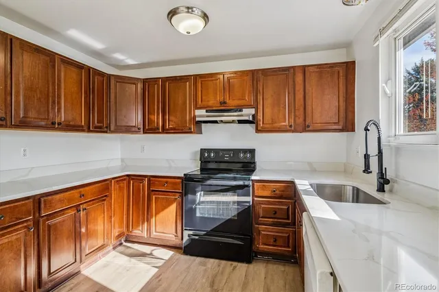 a kitchen with granite countertop wood cabinets stainless steel appliances and a window