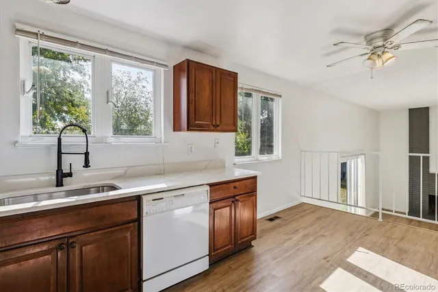 a kitchen with a sink cabinets appliances and a large window