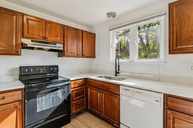 a kitchen with a sink stove top oven and cabinets