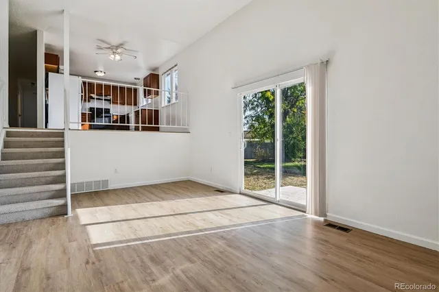 an empty room with wooden floor and windows