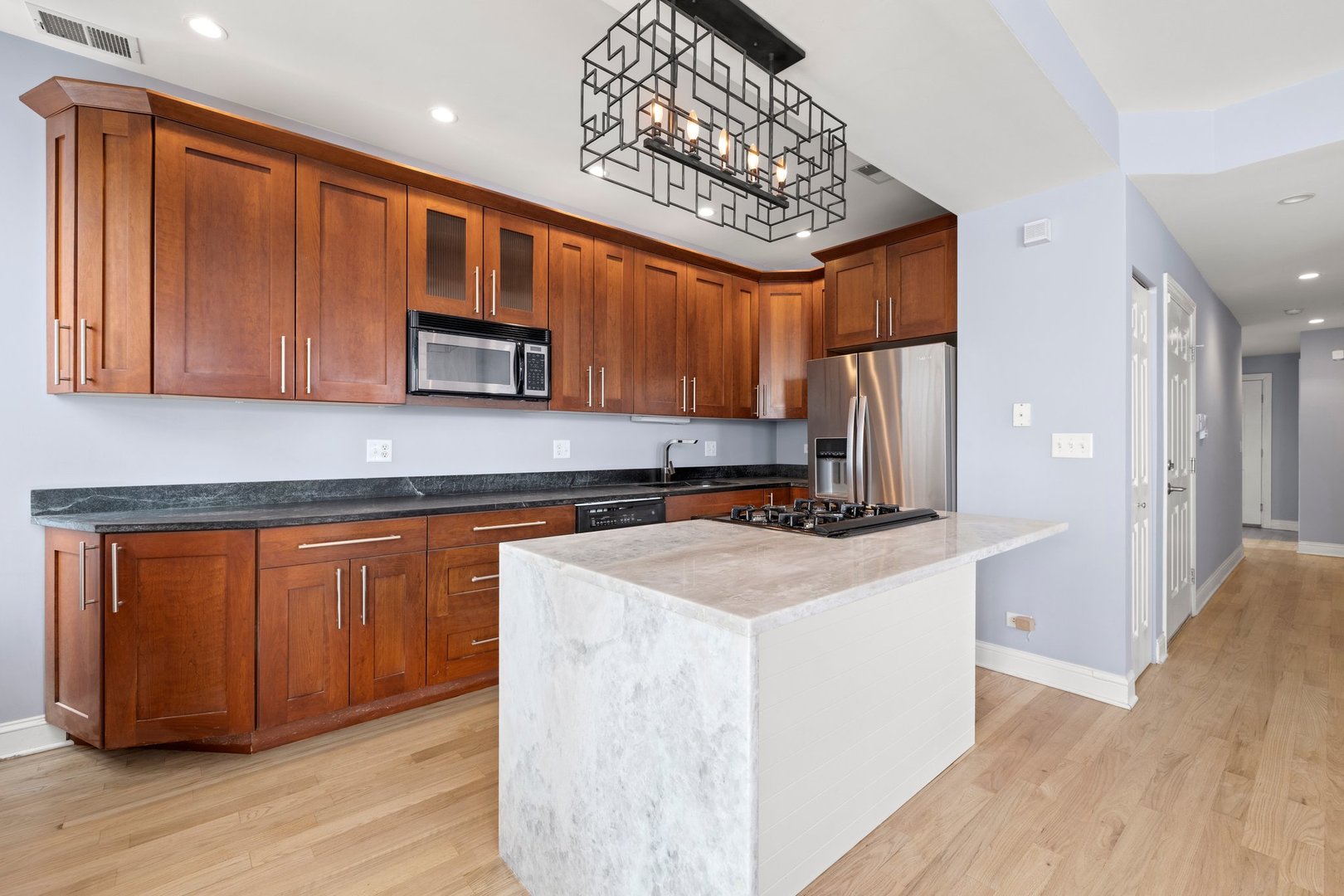 1122 North Oakley Boulevard, Unit C Chicago, IL 60622 - Photo 2 of 23 a kitchen with stainless steel appliances granite countertop wooden cabinets a stove a sink and dishwasher
