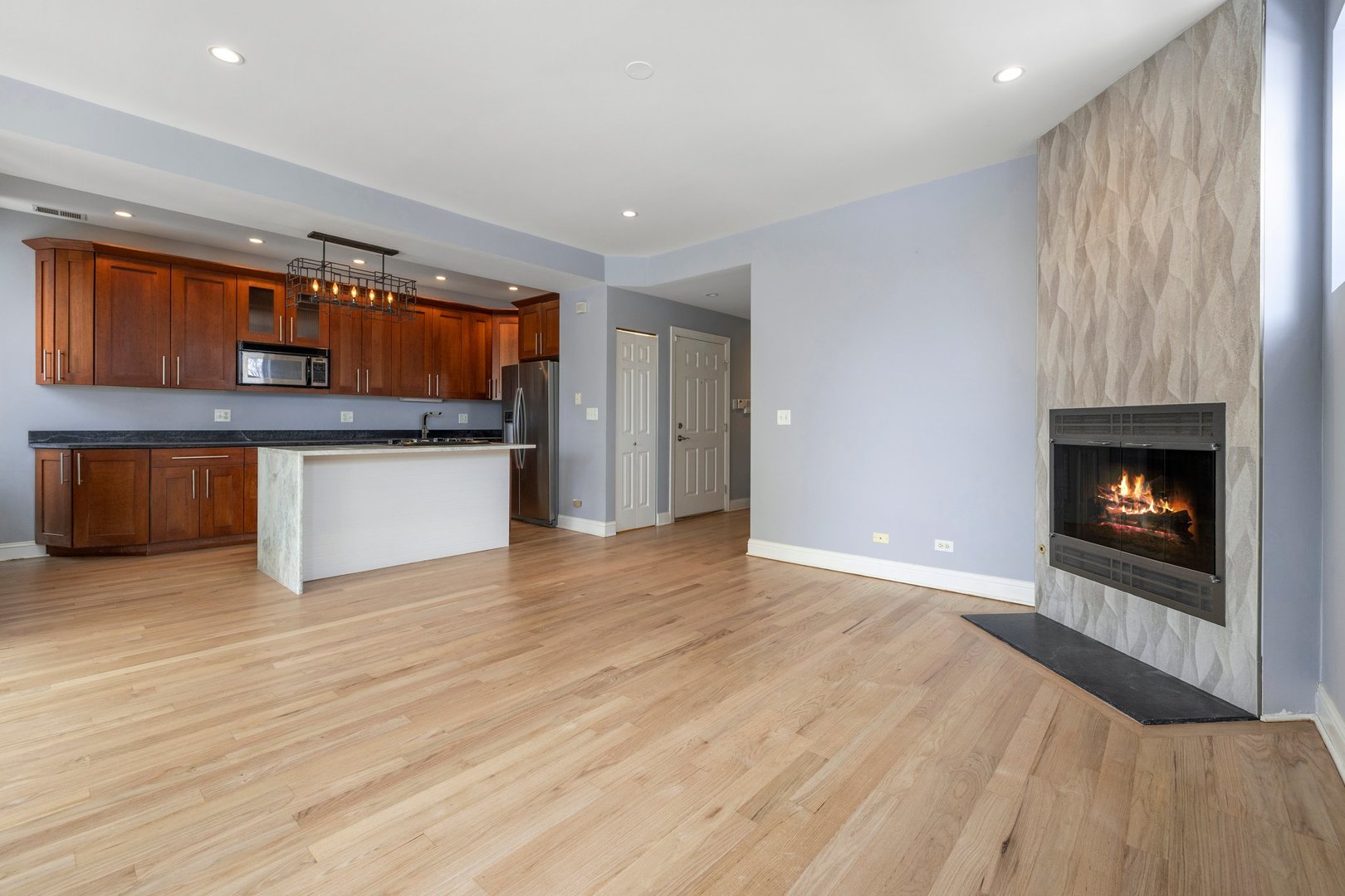 1122 North Oakley Boulevard, Unit C Chicago, IL 60622 - Photo 4 of 23 a view of an empty room with a fireplace and a window