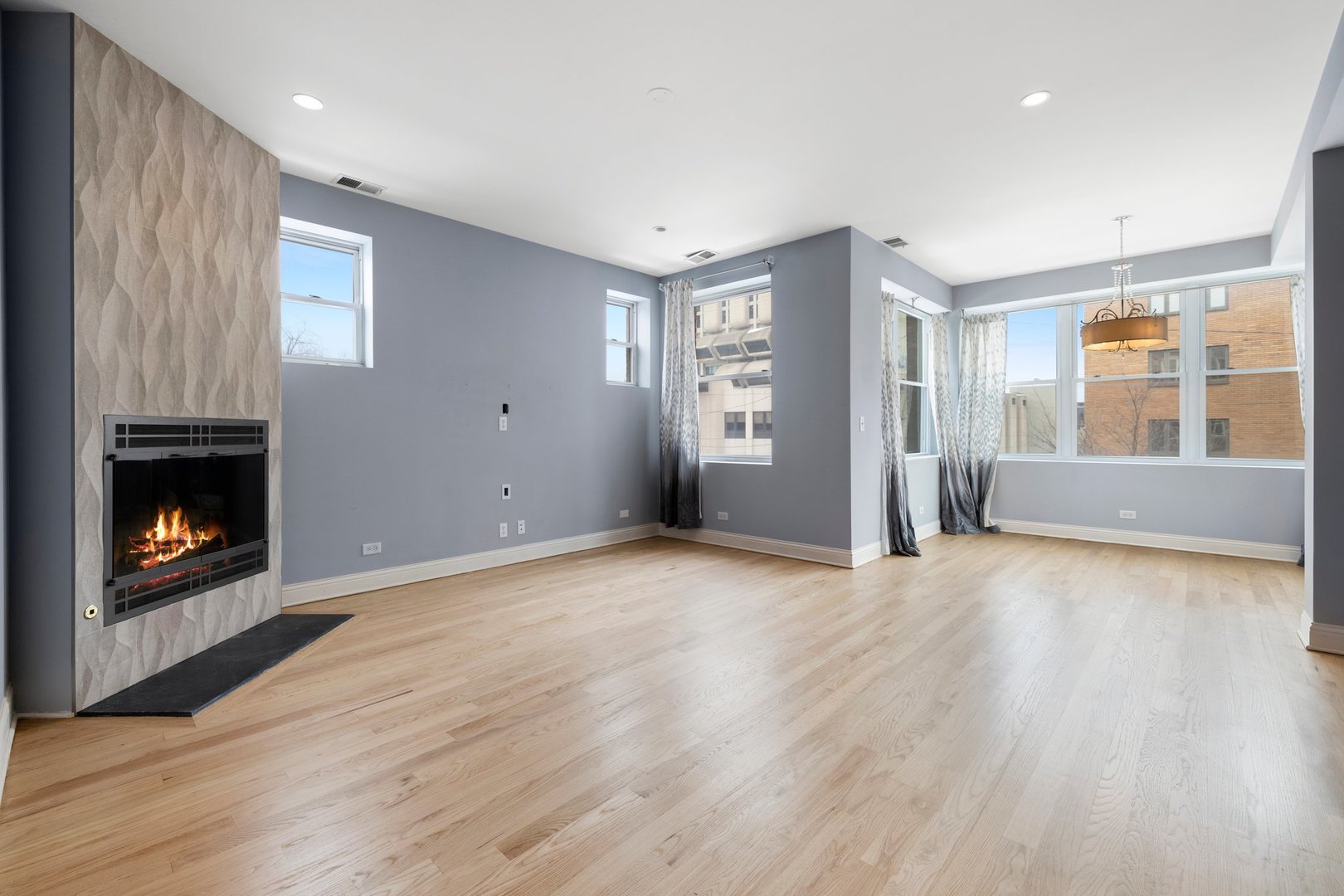 1122 North Oakley Boulevard, Unit C Chicago, IL 60622 - Photo 6 of 23 a view of an empty room with a fireplace and a window