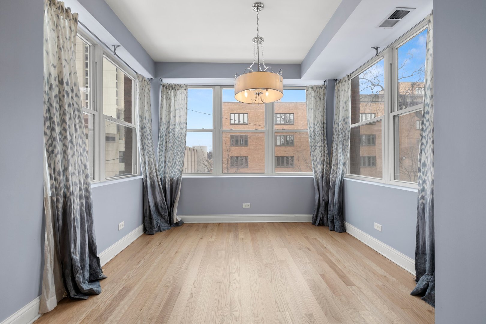 1122 North Oakley Boulevard, Unit C Chicago, IL 60622 - Photo 10 of 23 a view of an empty room with wooden floor and a window