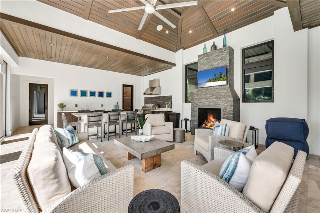 2025 Crayton Road Naples, FL 34102 - Photo 16 of 36 a living room with furniture and a fireplace