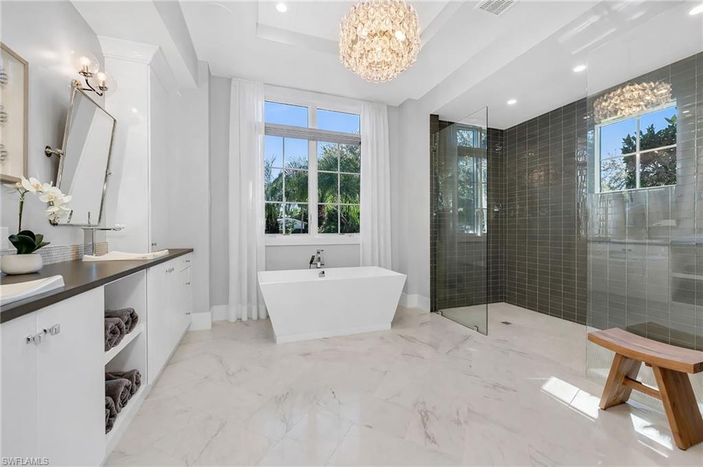 2025 Crayton Road Naples, FL 34102 - Photo 20 of 36 a spacious bathroom with a tub sink shower and mirror