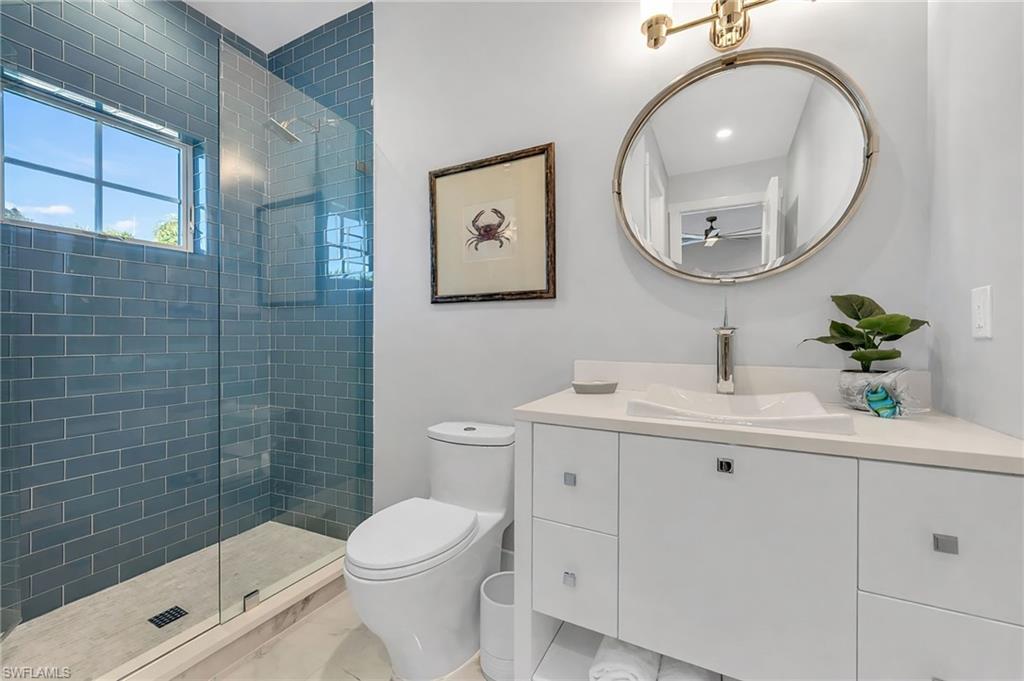 2025 Crayton Road Naples, FL 34102 - Photo 27 of 36 a bathroom with a sink a toilet and a mirror