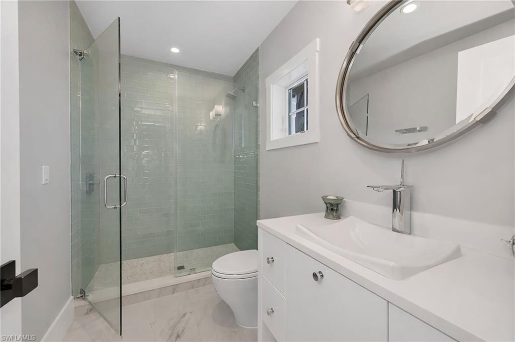 2025 Crayton Road Naples, FL 34102 - Photo 29 of 36 a bathroom with a sink a toilet and shower