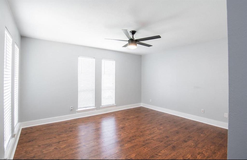 5808 Sandhurst Lane, Unit A Dallas, TX 75206 - Photo 2 of 9 an empty room with wooden floor fan and windows