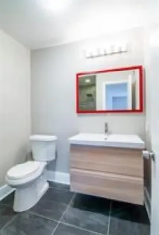 a bathroom with a toilet sink and mirror