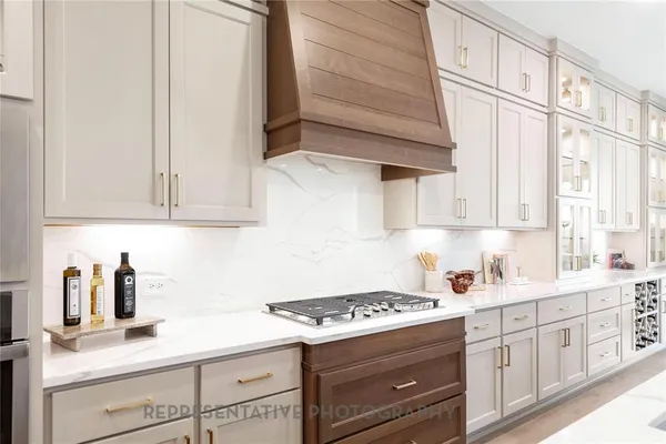 a kitchen with stainless steel appliances white cabinets and a stove top oven