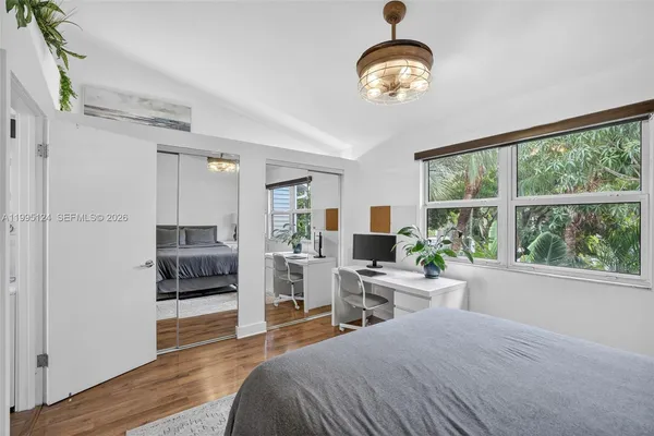 a bedroom with a bed and a large window