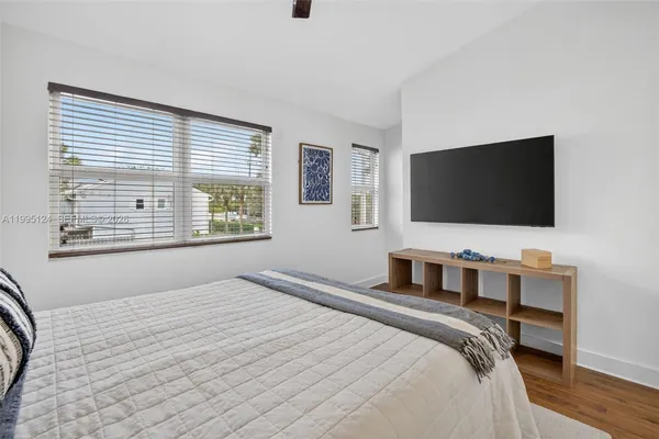 a bedroom with a bed and a flat screen tv