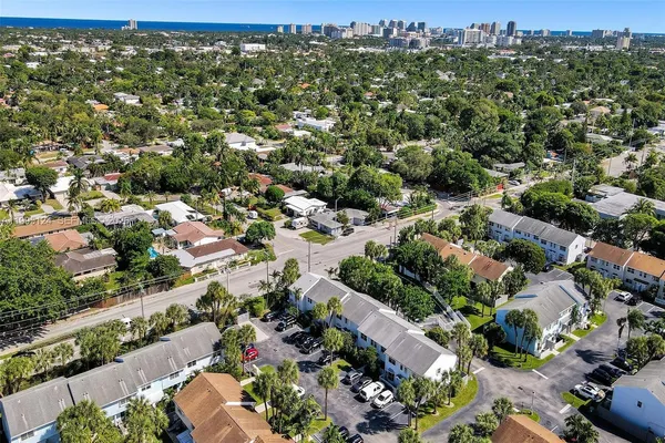 an aerial view of residential houses with outdoor space and trees