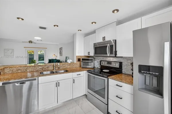 a kitchen with granite countertop a refrigerator and a sink