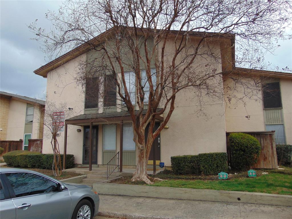 a front view of a house with yard and parking