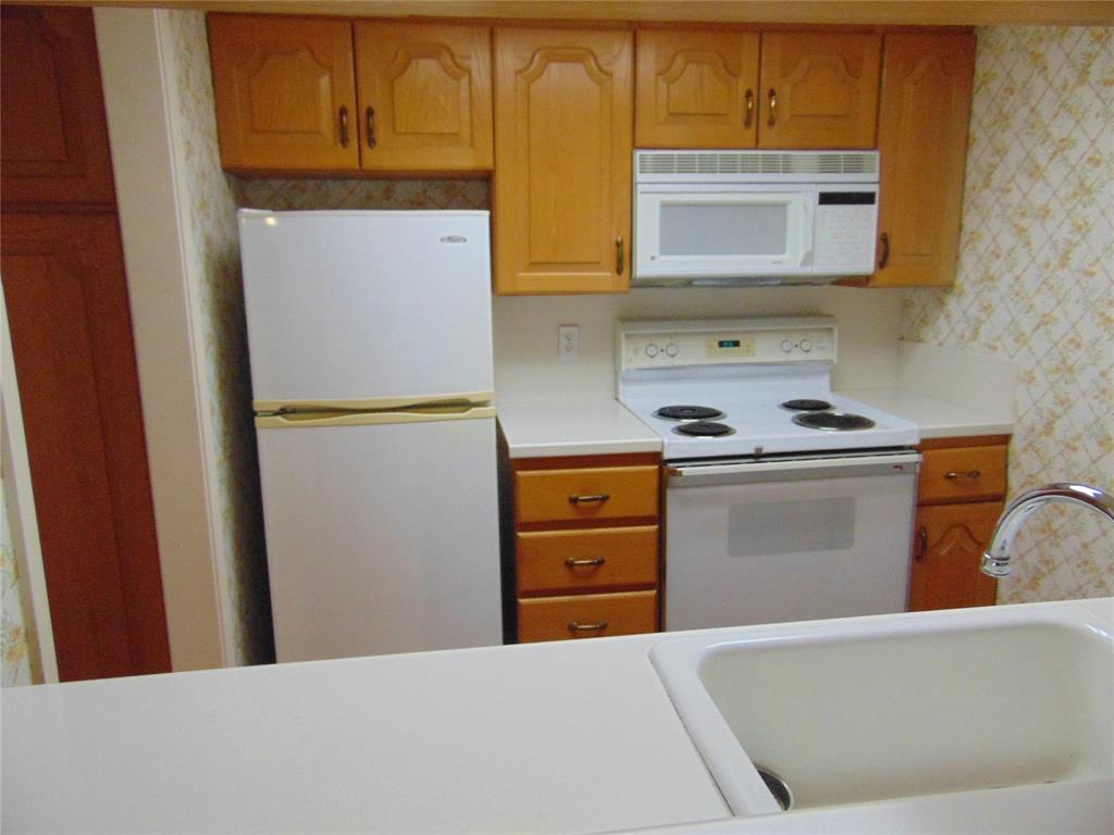 12806 Midway Road, Unit 2020 Dallas, TX 75244 - Photo 11 of 18 a kitchen with stainless steel appliances a stove and a refrigerator