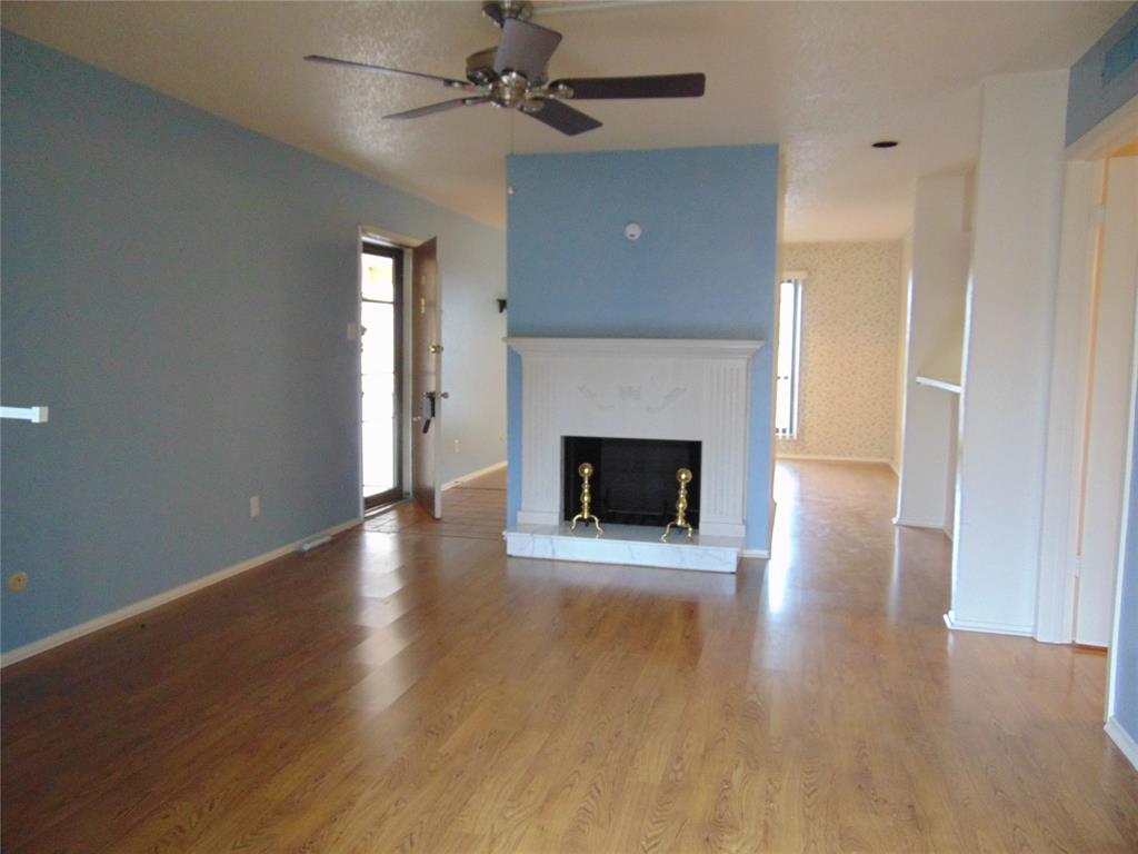 12806 Midway Road, Unit 2020 Dallas, TX 75244 - Photo 2 of 18 an empty room with wooden floor a fireplace