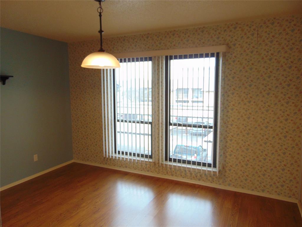 12806 Midway Road, Unit 2020 Dallas, TX 75244 - Photo 5 of 18 a view of an empty room with wooden floor and a window