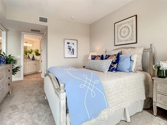 a bedroom with bed and paintings on the wall