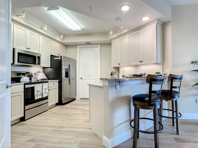 a kitchen with stainless steel appliances a stove a sink refrigerator and a microwave