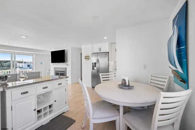 a kitchen with a dining table chairs cabinets and stainless steel appliances