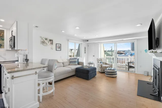 a living room with furniture a flat screen tv and a large window