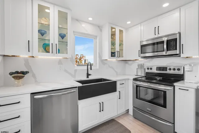 a kitchen with stainless steel appliances white cabinets and a sink