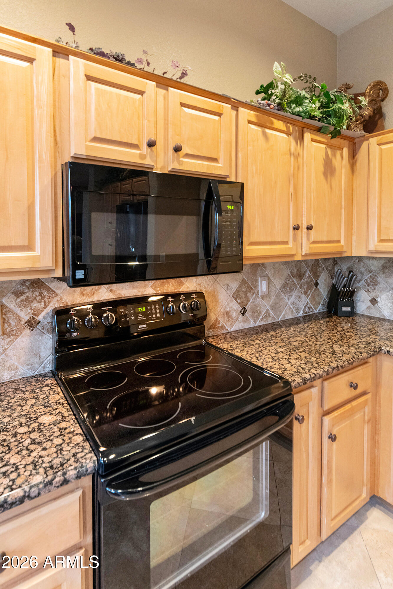 4100 East Strawberry Drive Gilbert, AZ 85298 - Photo 22 of 62 a kitchen with granite countertop a stove and a microwave