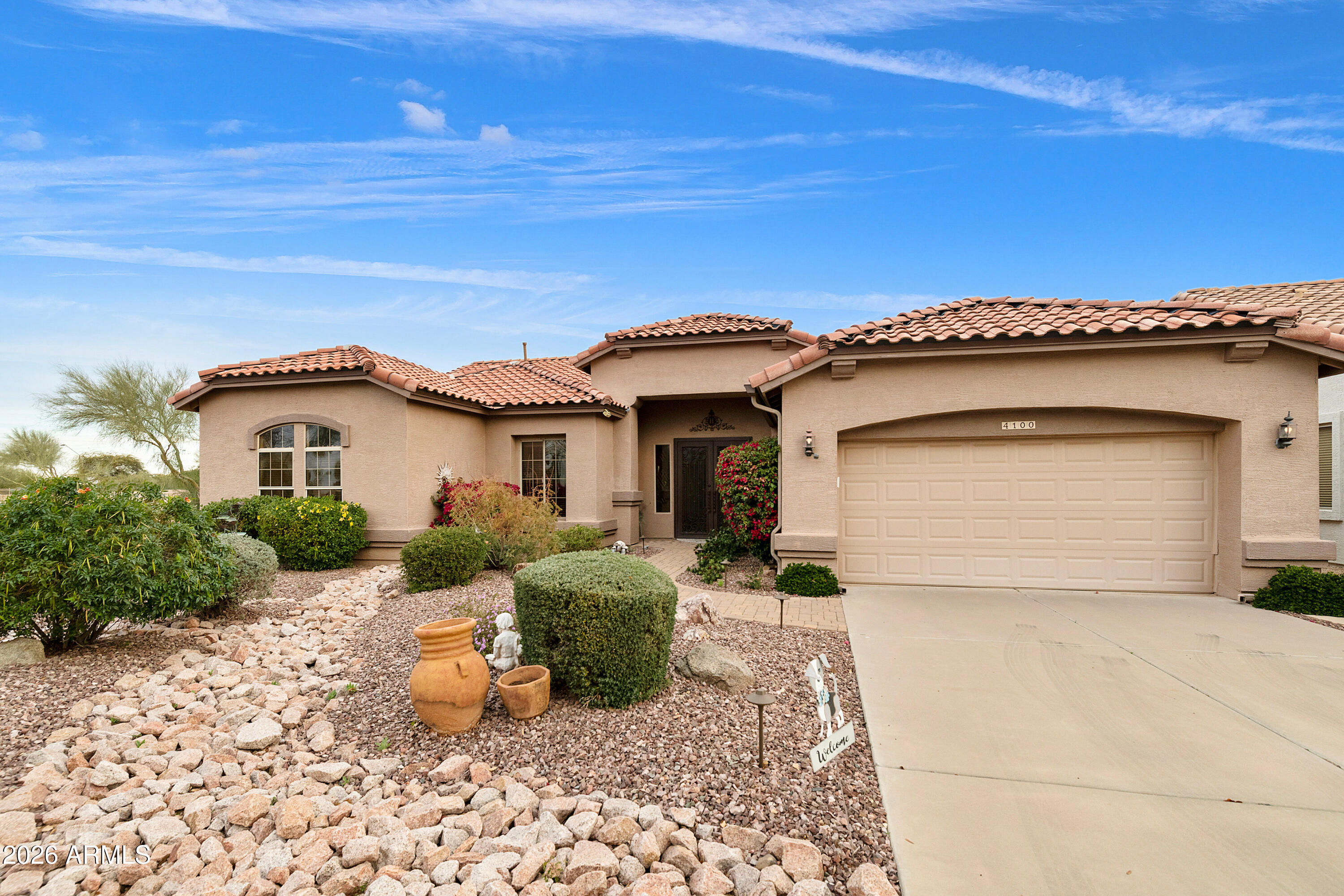 4100 East Strawberry Drive Gilbert, AZ 85298 - Photo 5 of 62 a front view of a house with a yard and garage