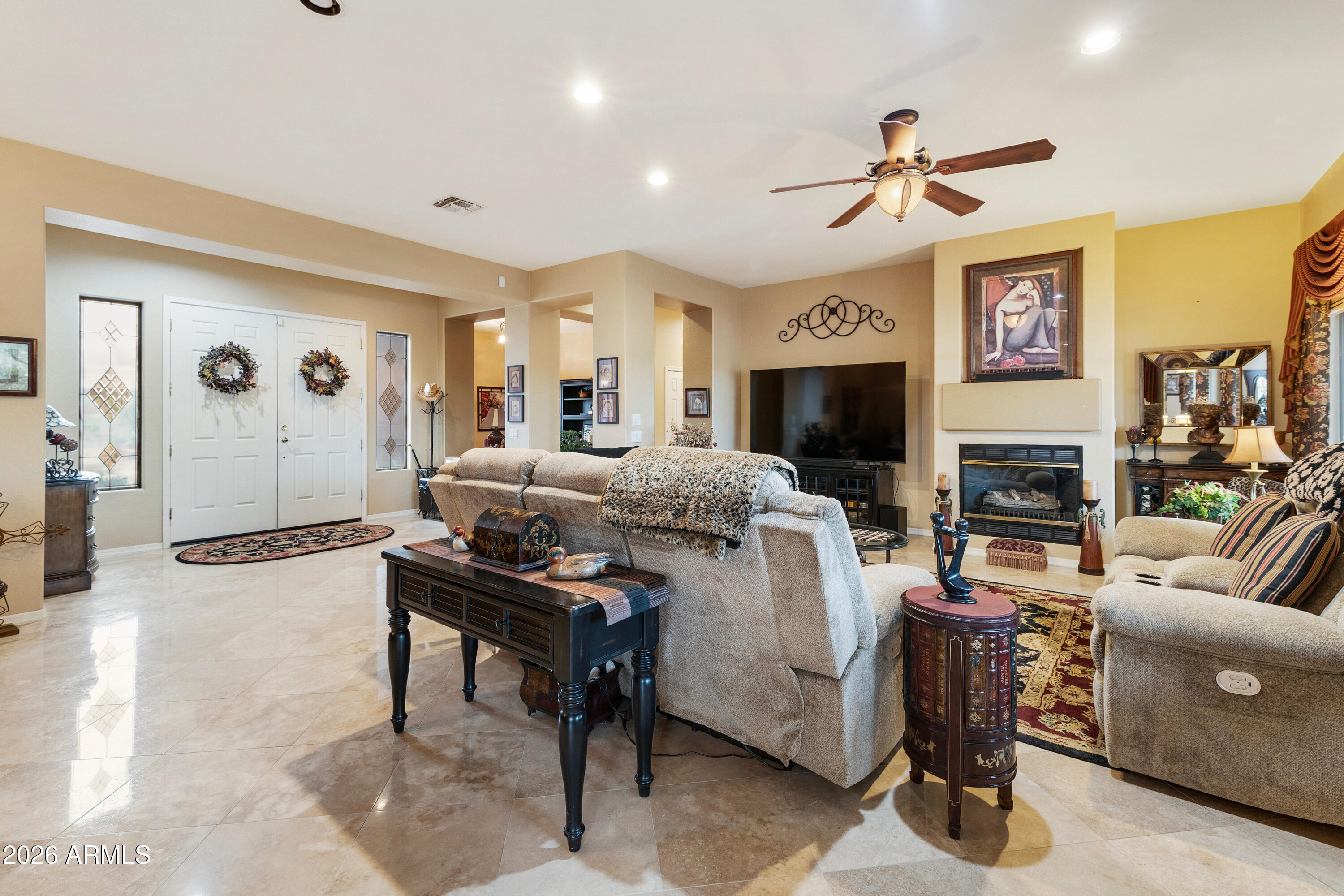 4100 East Strawberry Drive Gilbert, AZ 85298 - Photo 10 of 62 a living room with furniture a fireplace and a flat screen tv