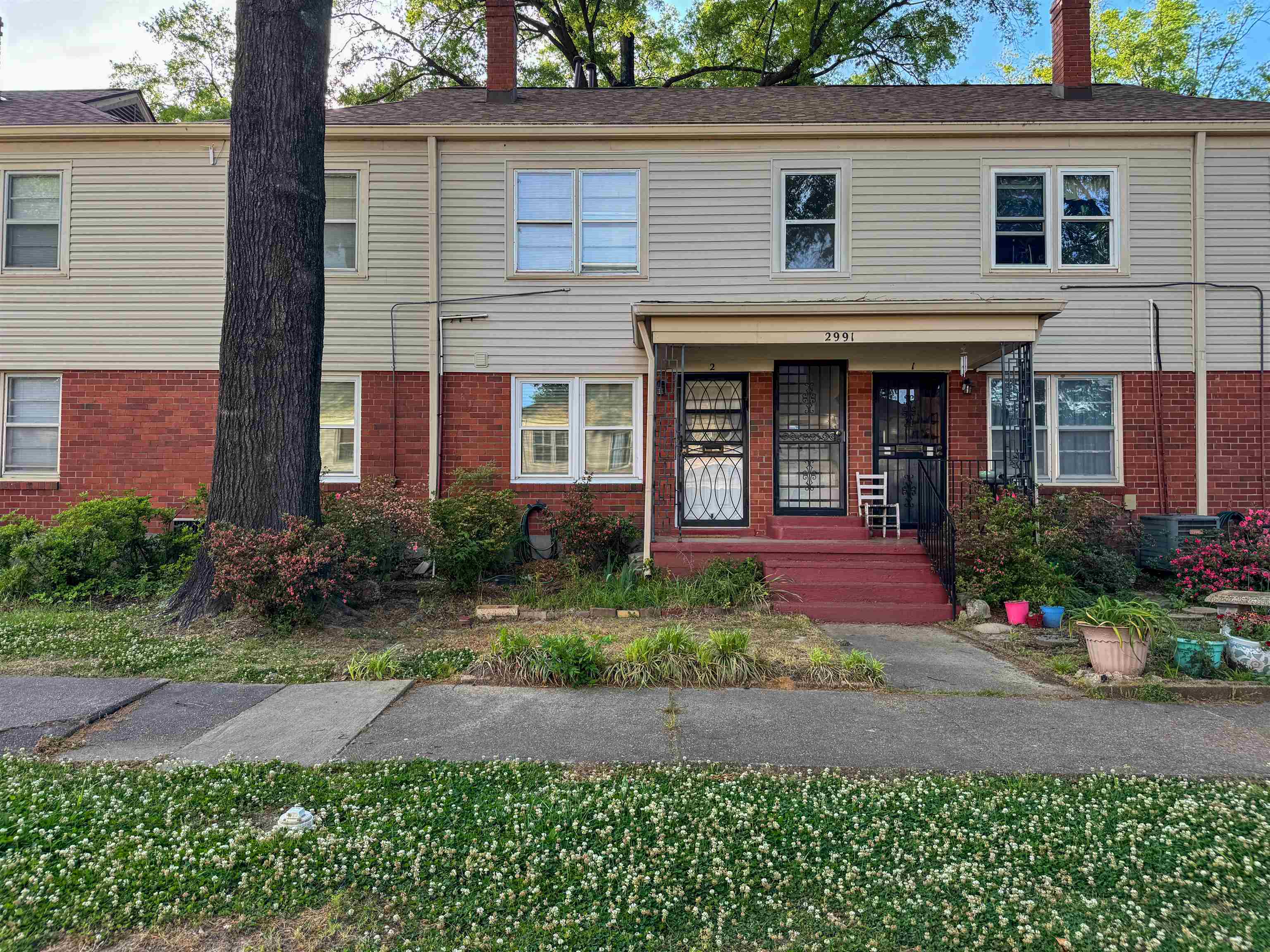 2991 Walnut Grove Road, Unit 2 Memphis, TN 38111 - Photo 2 of 8 a front view of a house with a yard and potted plants
