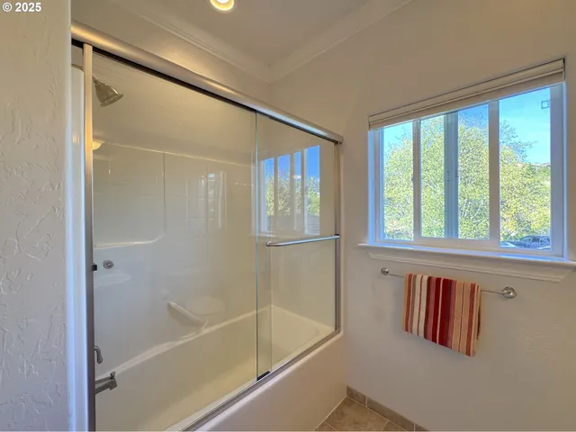 a bathroom with a granite countertop sink toilet mirror vanity and a shower