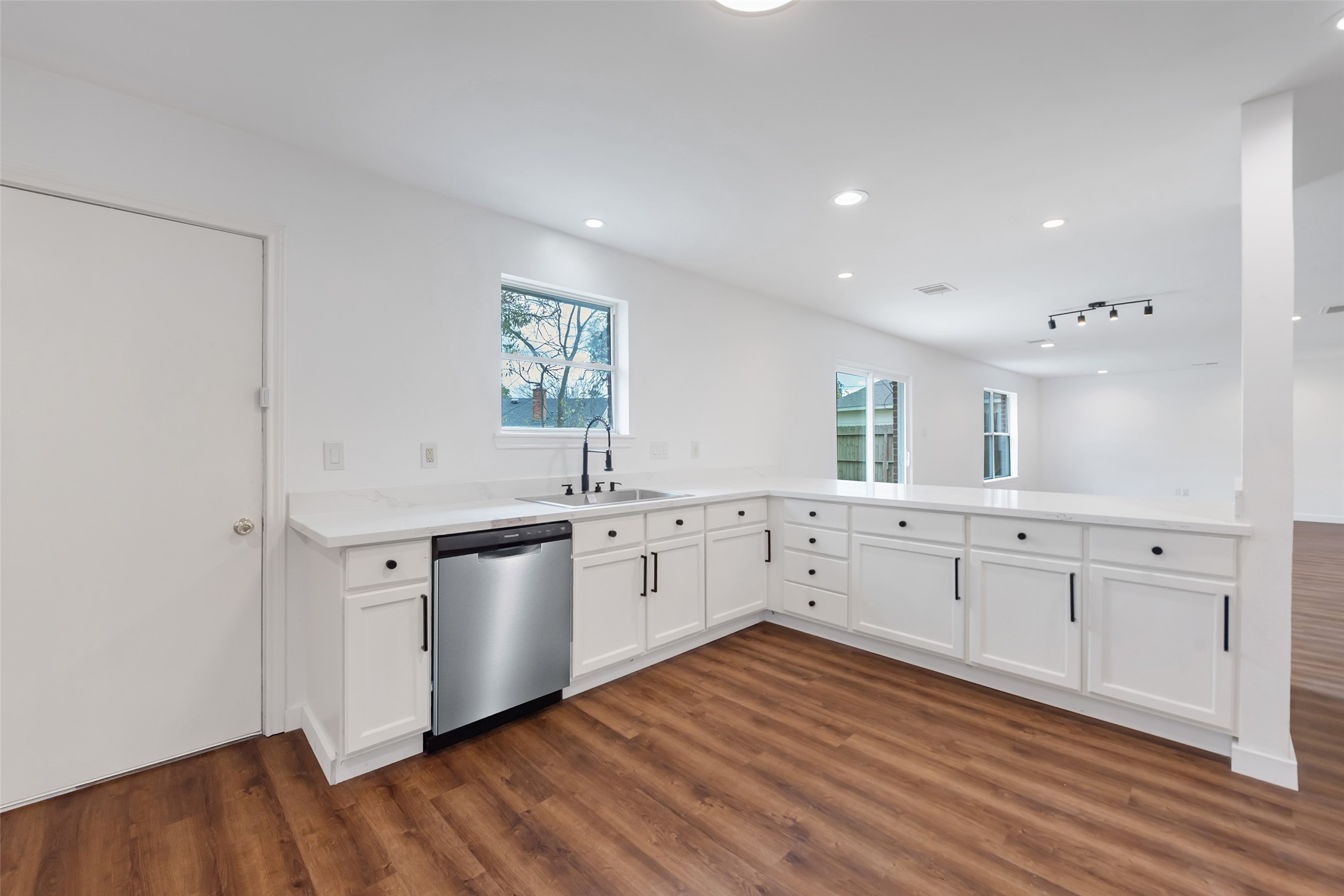 11703 North Perry Avenue Houston, TX 77071 - Photo 18 of 43 a large white kitchen with a sink and dishwasher a stove with wooden floor