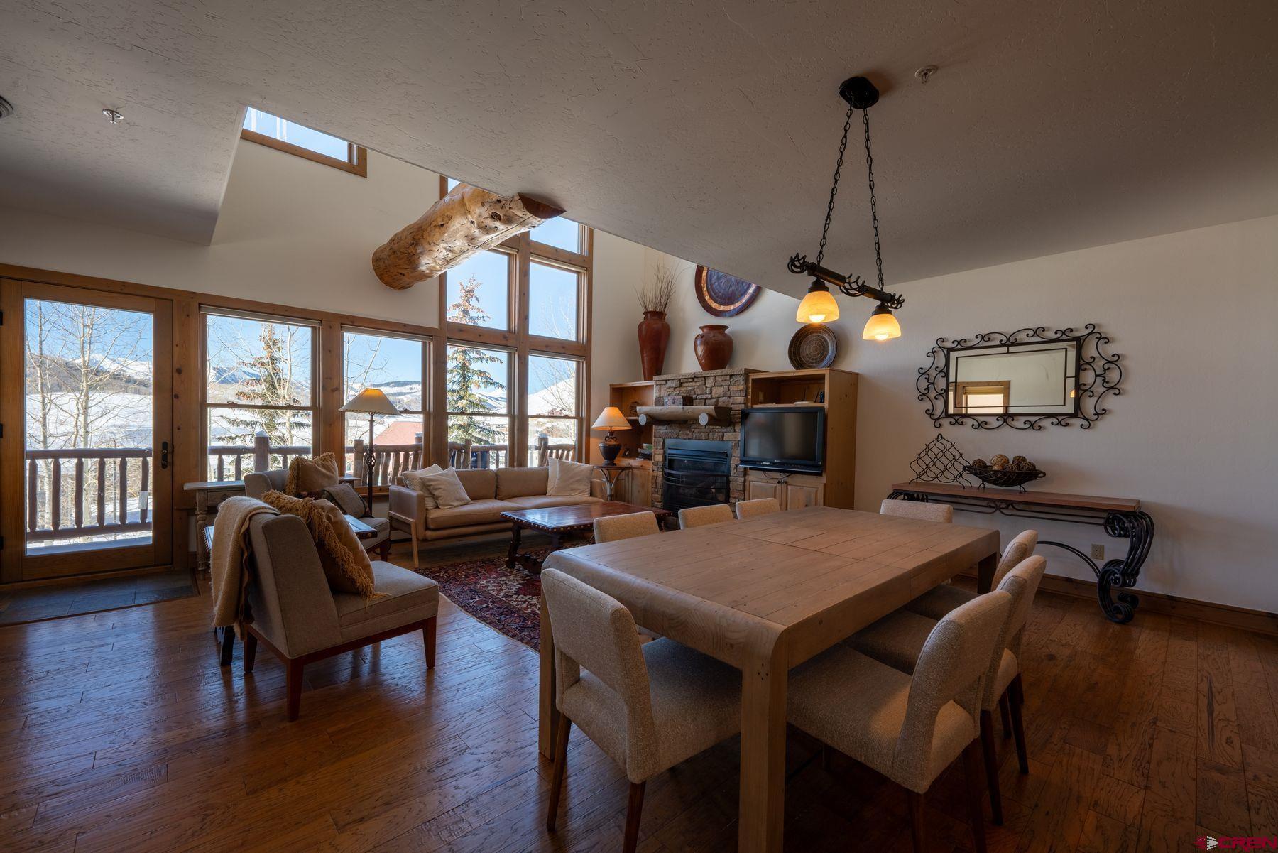 24 Hunter Hill Road, Unit 8 Crested Butte, CO 81225 - Photo 10 of 34 a dining room with wooden floor a chandelier a wooden table and chairs