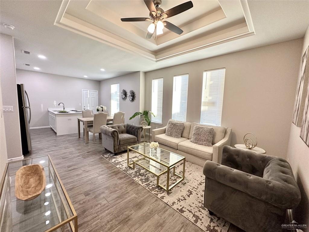 3302 Wolf Creek Avenue, Unit 4 Edinburg, TX 78541 - Photo 3 of 12 a living room with lots of furniture and a chandelier