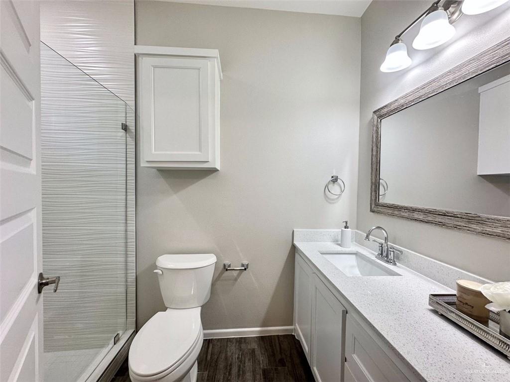 3302 Wolf Creek Avenue, Unit 4 Edinburg, TX 78541 - Photo 8 of 12 a bathroom with a granite countertop toilet sink and mirror