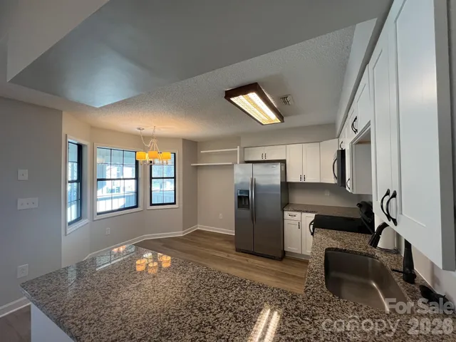 a kitchen with stainless steel appliances granite countertop a refrigerator and a sink