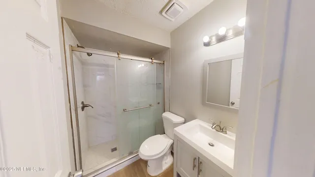 a bathroom with a granite countertop toilet sink and shower