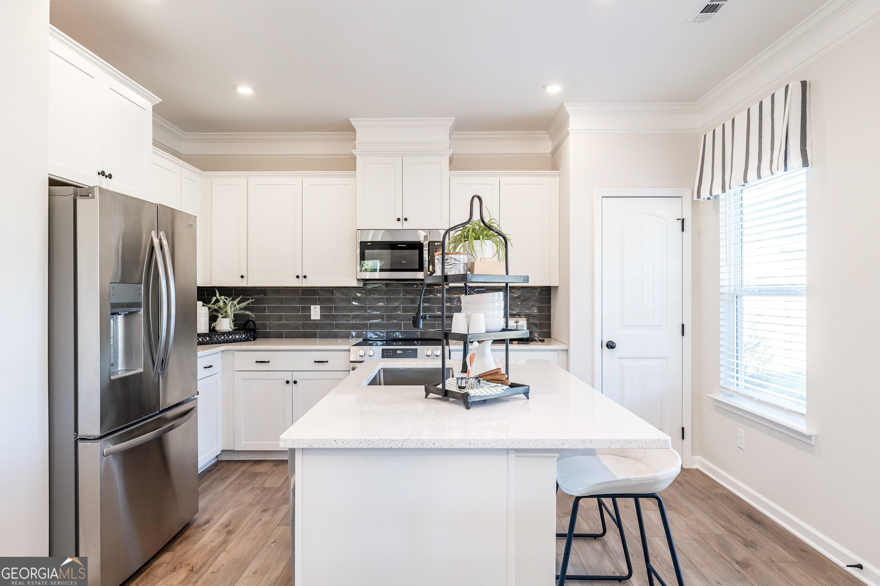 10410 Trellis Lane, Unit (LOT 35) Hampton, GA 30228 - Photo 16 of 28 a kitchen that has a kitchen island wooden cabinets and stainless steel appliances