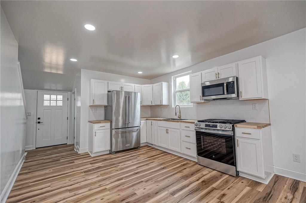 242 Dickens Street Latrobe, PA 15650 - Photo 6 of 25 a kitchen with stainless steel appliances granite countertop a stove top oven and refrigerator