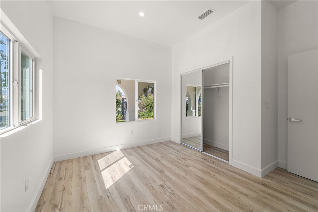 10730 Strathern Street Sun Valley, CA 91352 - Photo 12 of 57 an empty room with wooden floor and windows