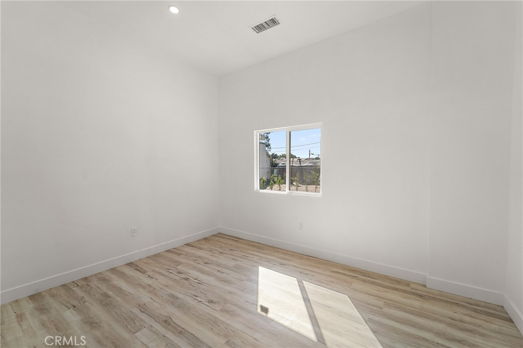 10730 Strathern Street Sun Valley, CA 91352 - Photo 15 of 57 an empty room with wooden floor and windows
