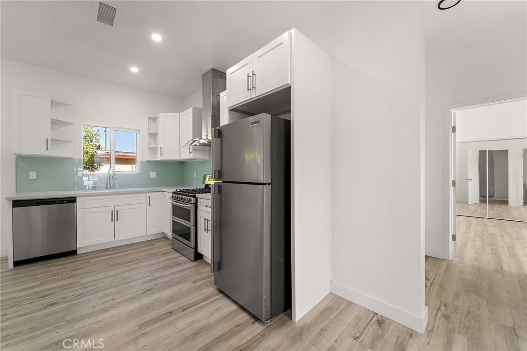 10730 Strathern Street Sun Valley, CA 91352 - Photo 20 of 57 a kitchen with a refrigerator sink and wooden floor
