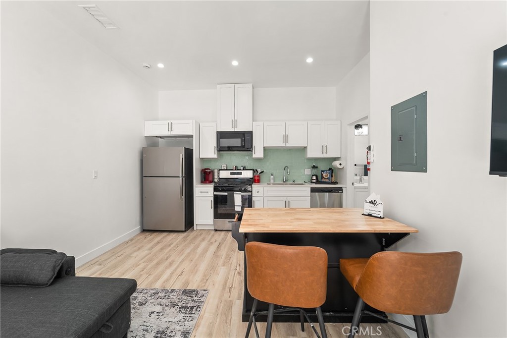 10730 Strathern Street Sun Valley, CA 91352 - Photo 40 of 57 a kitchen with stainless steel appliances a dining table chairs and refrigerator