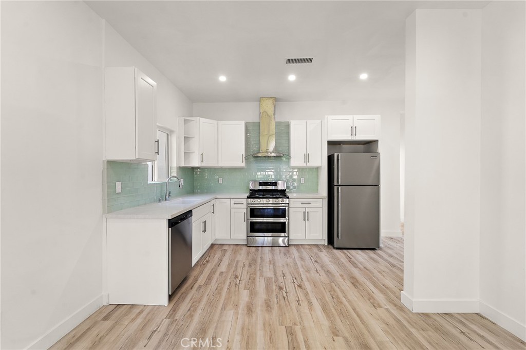 10730 Strathern Street Sun Valley, CA 91352 - Photo 6 of 57 a kitchen with stainless steel appliances a refrigerator sink and stove top oven
