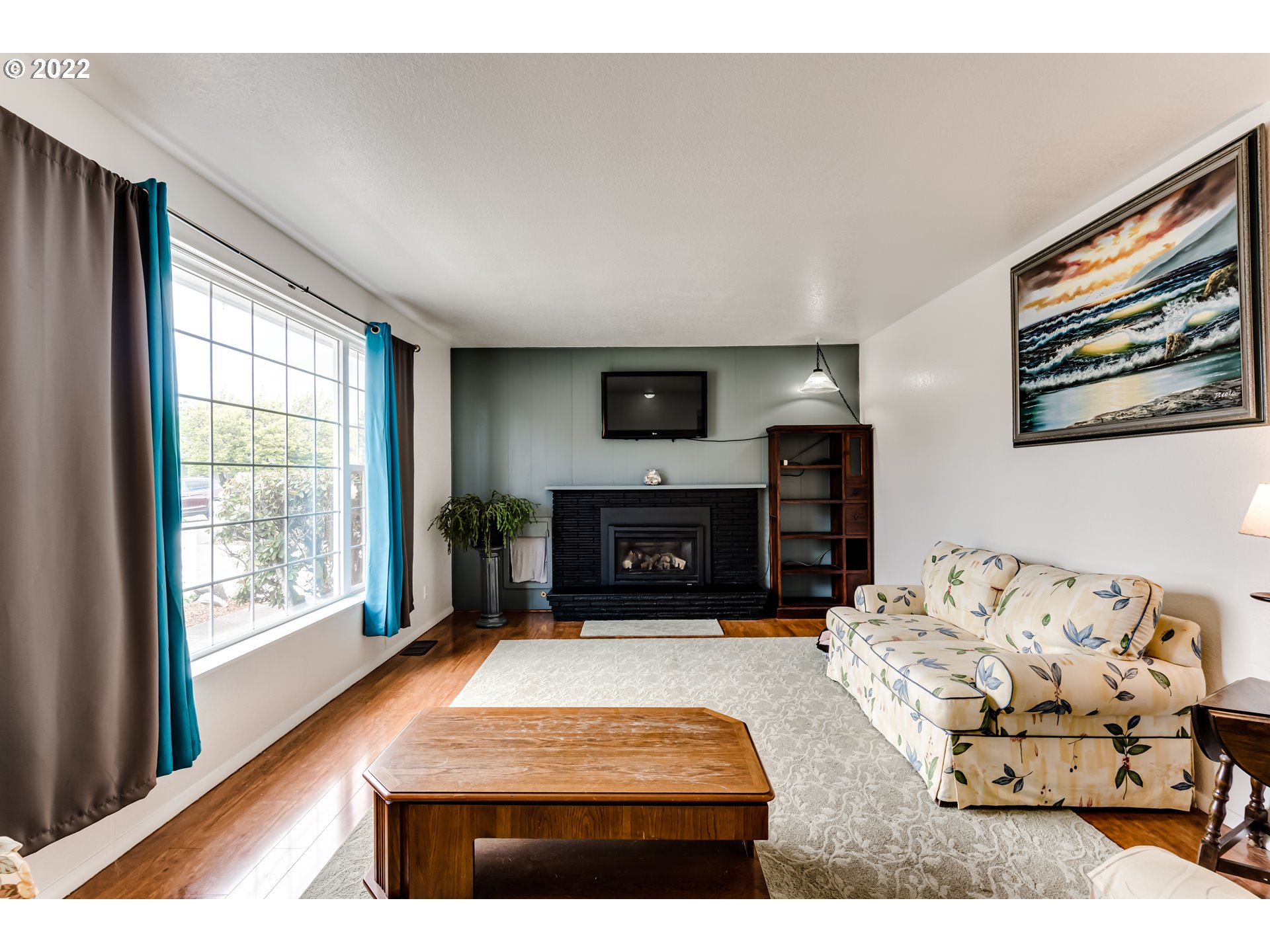 345 Mansfield Street Springfield, OR 97477 - Photo 5 of 31 a living room with furniture large window and a fireplace