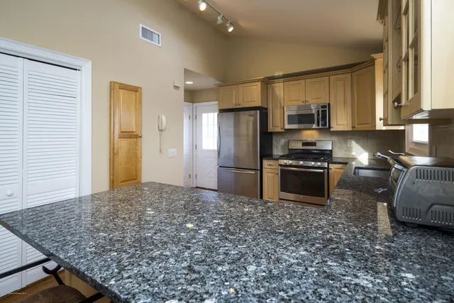 a kitchen with stainless steel appliances granite countertop a refrigerator stove and oven